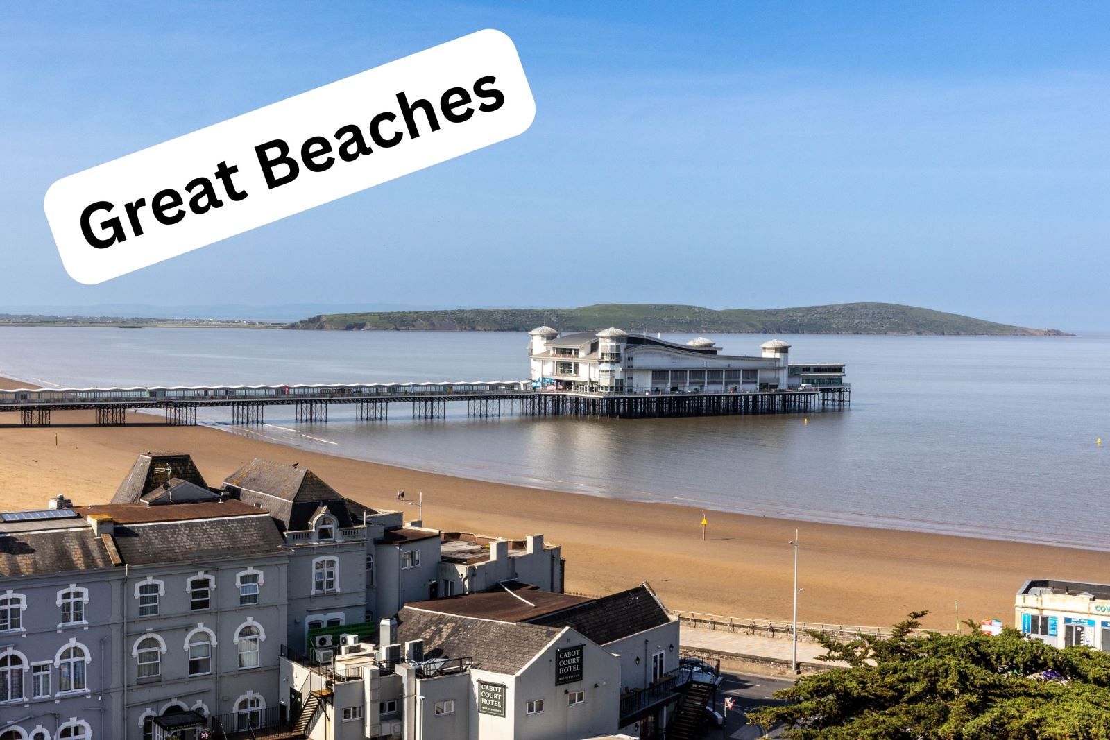 Aerial view of a sandy beach with a pier